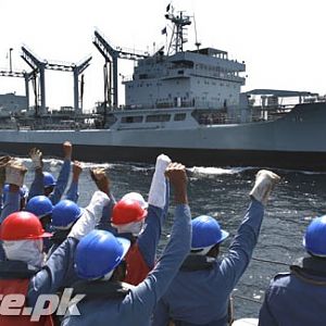 Pakistan Navy personnel raise their fists and shout slogans.