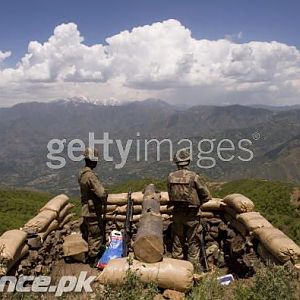 Soldiers stand guard on top of a mountain