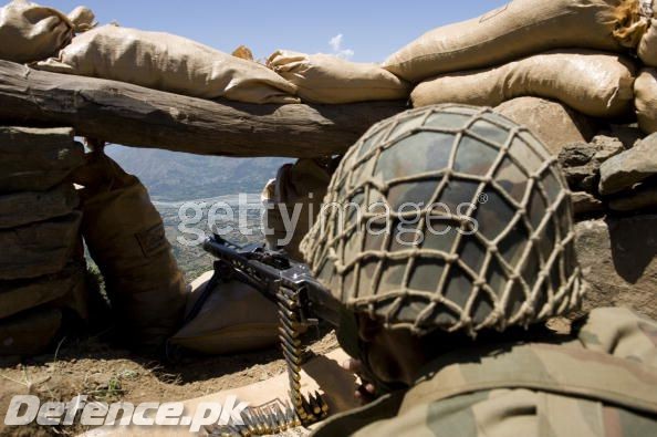 Soldier aiming his weapon on top of a mountain