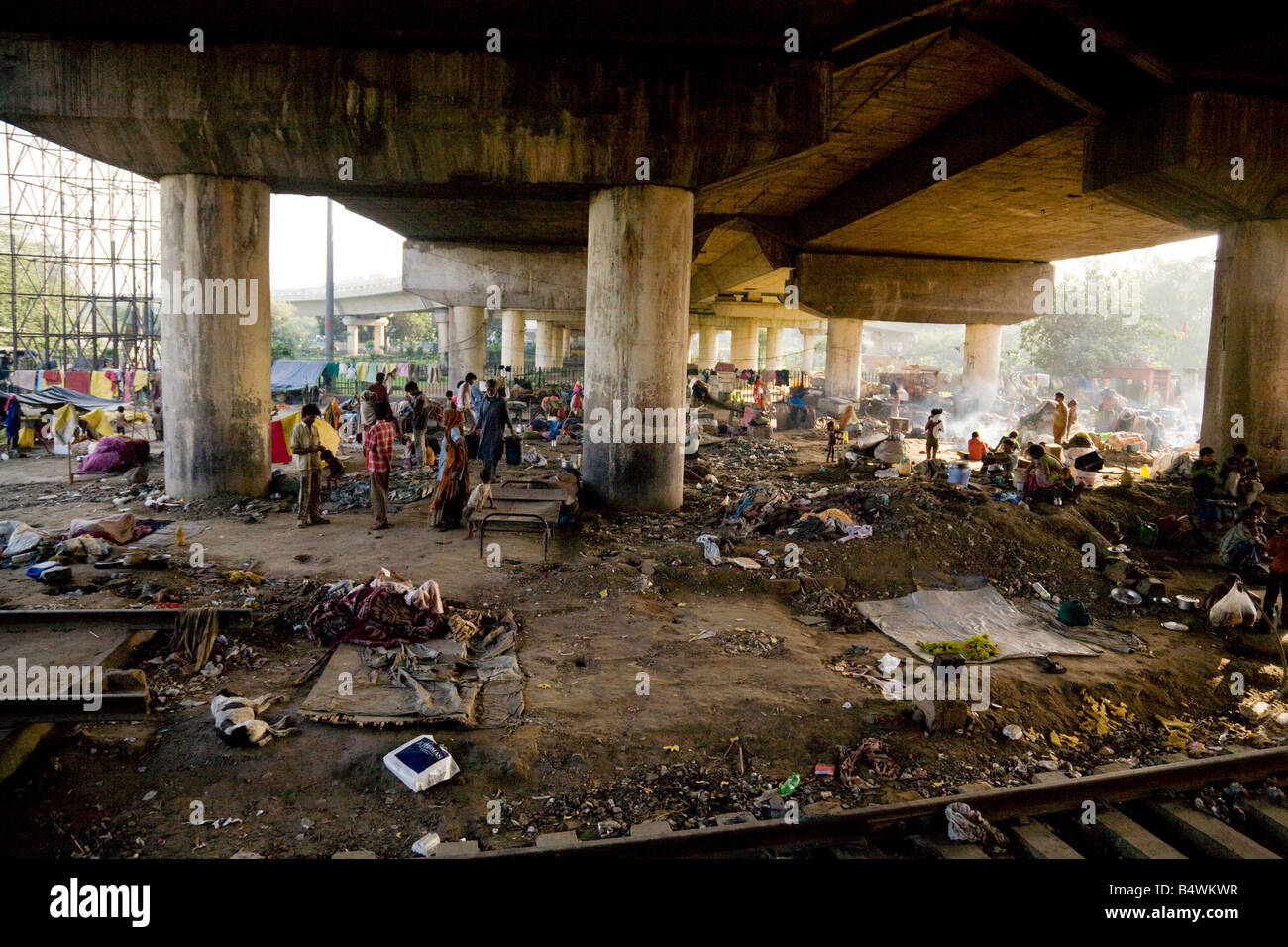crowds-of-people-living-in-slums-under-the-bridge-by-the-delhi-to-B4WKWR.jpg