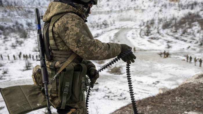 A Ukrainian Army soldier unloads ammunition for a belt-fed machine gun in the Donbas region of eastern Ukraine