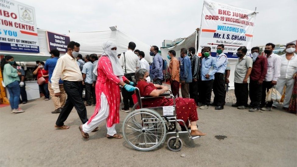 A woman in a wheelchair leaves a vaccination centre after receiving a dose of the coronavirus disease (COVID-19) vaccine during a vaccination drive, in Mumbai, India, April 8, 2021