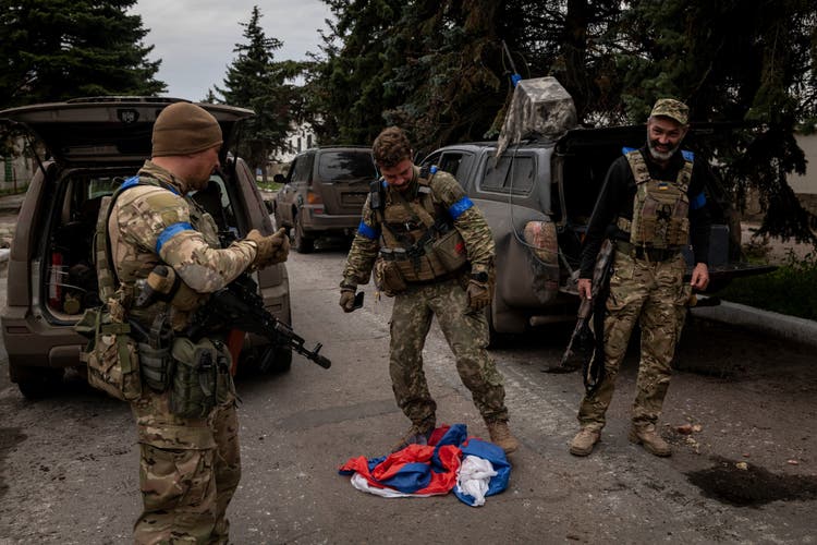 Ukrainische Soldaten zertreten nach der Befreiung von Liman eine russische Flagge.
