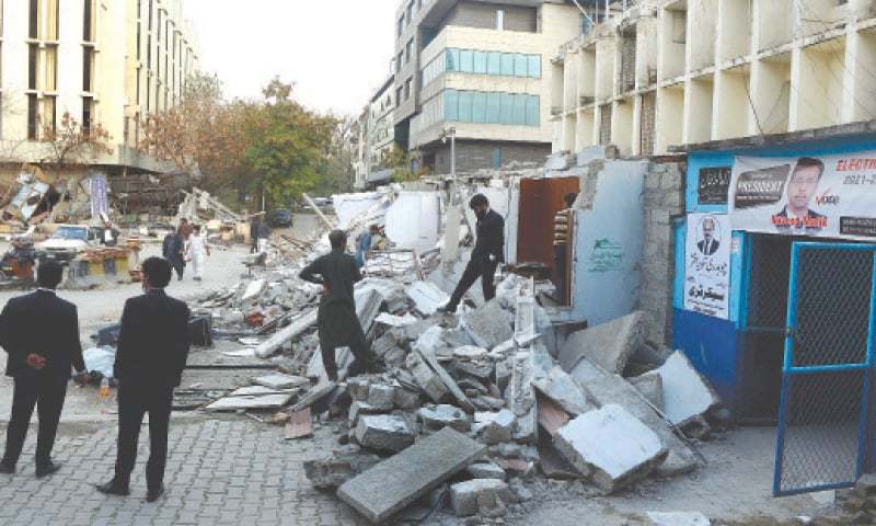 This file photo shows lawyers pictured at the debris of their demolished chambers  on Monday.—Mohammad Asim / White Star