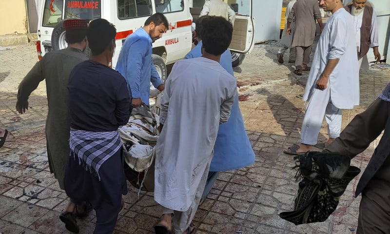 People carry the body of a victim following an explosion at a mosque in Kunduz, Afghanistan. — AP