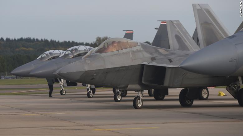 A US Air Force F-22 Raptor lines up next to three F-15E Strike Eagles at Royal Air Force Lakenheath, England, in 2017. 