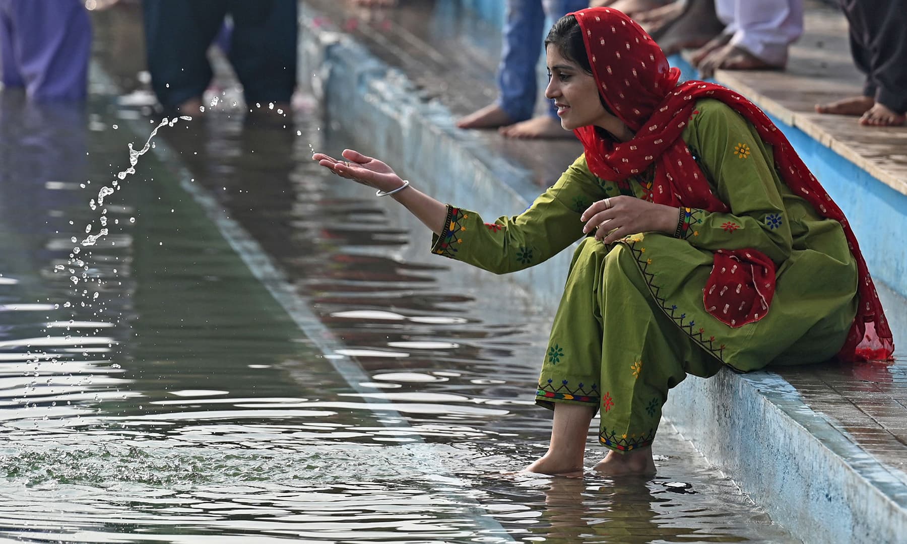 A Sikh pilgrim sits next to the holy sarovar, or sacred pool, on the occasion of the birth anniversary of Guru Nanak Dev in Nankana Sahib on November 19. — AFP