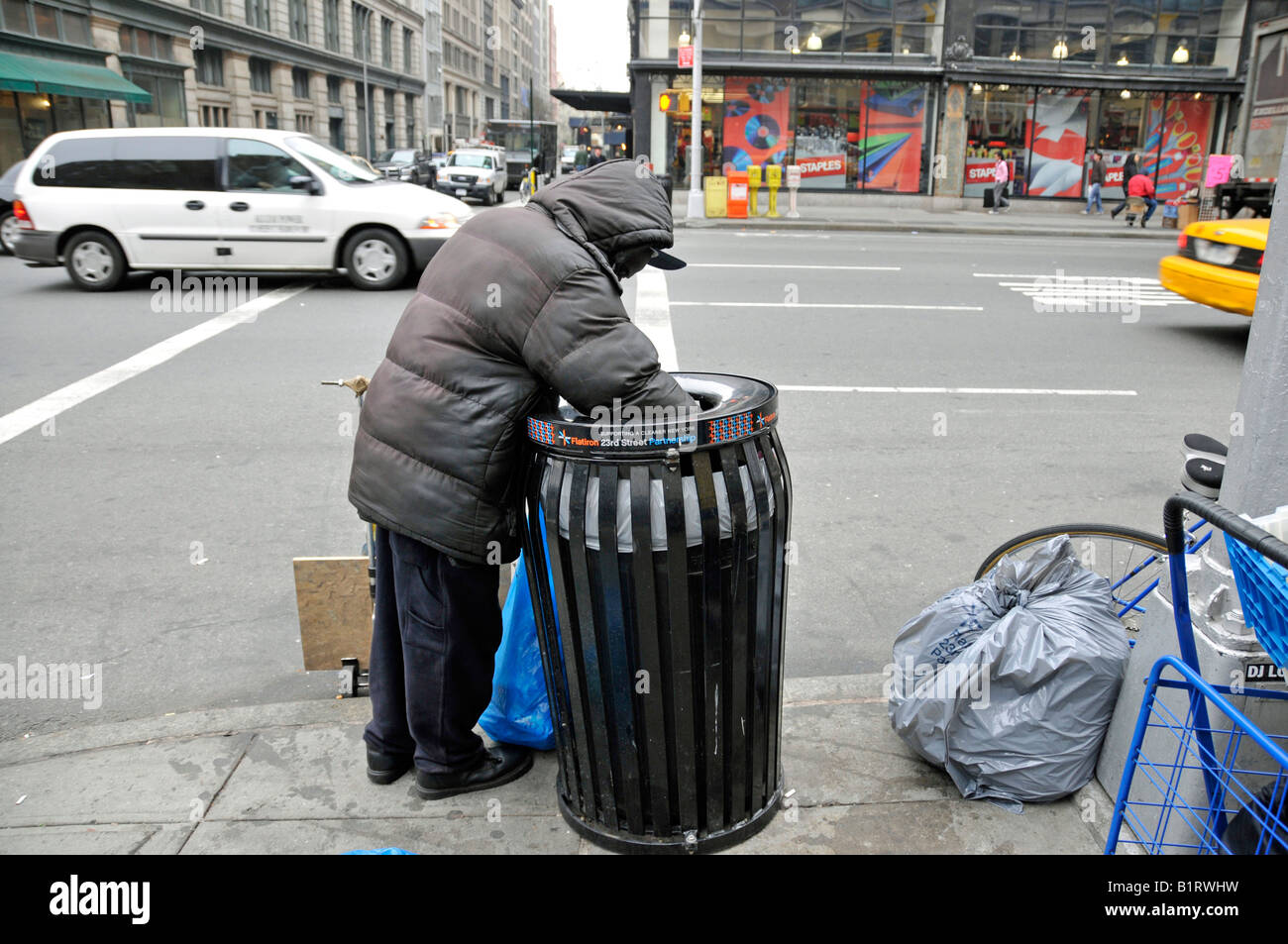 homeless-person-rummaging-through-a-trash-can-looking-for-salvageable-B1RWHW.jpg