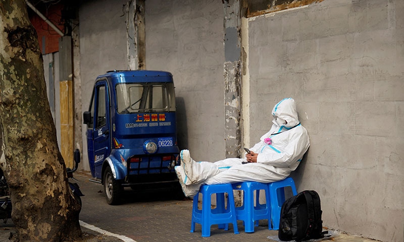 A worker in a protective suit sits on plastic stools following the coronavirus outbreak in Shanghai, China on Wednesday. — Reuters