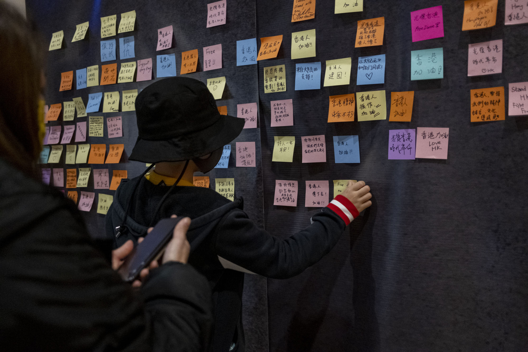 An audience member of a screening of the documentary film “Revolution of Our Times” affixes a message of support for the Hong Kong protest movement at a cinema in Vancouver in February. Photo: CanMen
