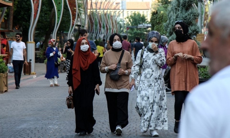 People wearing protective face masks walk along a street amid a surge in Covid-19 cases in Turkey. — Reuters