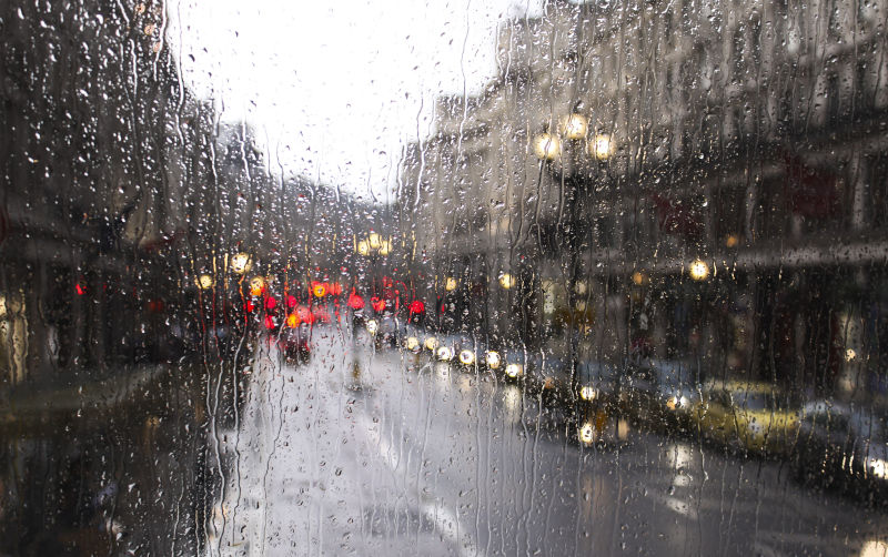 Blurred view of road traffic in London on a rainy day through the bus window. raindrops on the glass window of the bus.