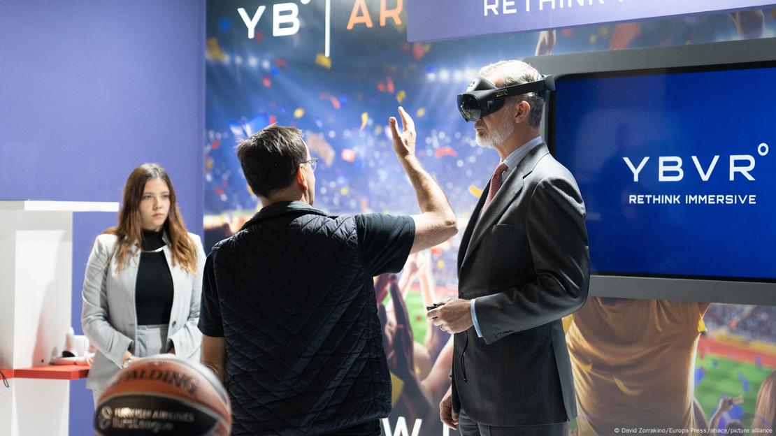 King Felipe VI wears virtual glasses at a stand at the Mobile World Congress 