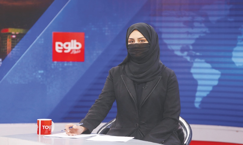 AN Afghan woman, while covering her face, presents a programme at TOLOnews channel.—Reuters