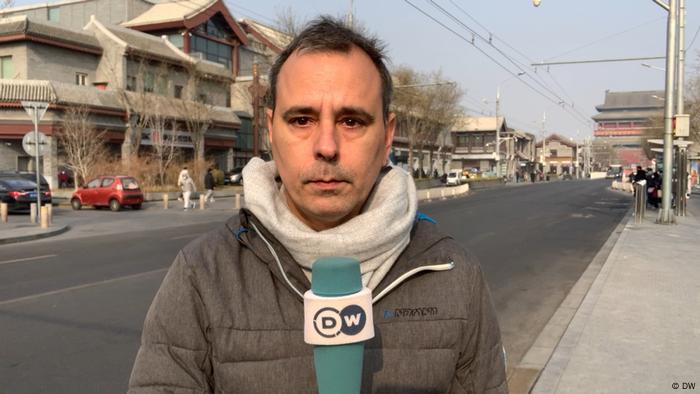 Mathias Bölinger, man standing on an empty street holding microphone looks into camera 