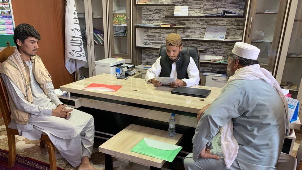 Ainudeen sitting at a desk in his office in Balkh province