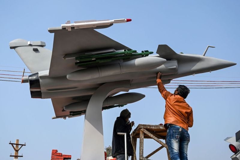 Workers put final touches on a model of a Rafale fighter jet ahead of the Republic Day parade in New Delhi on Jan 22.