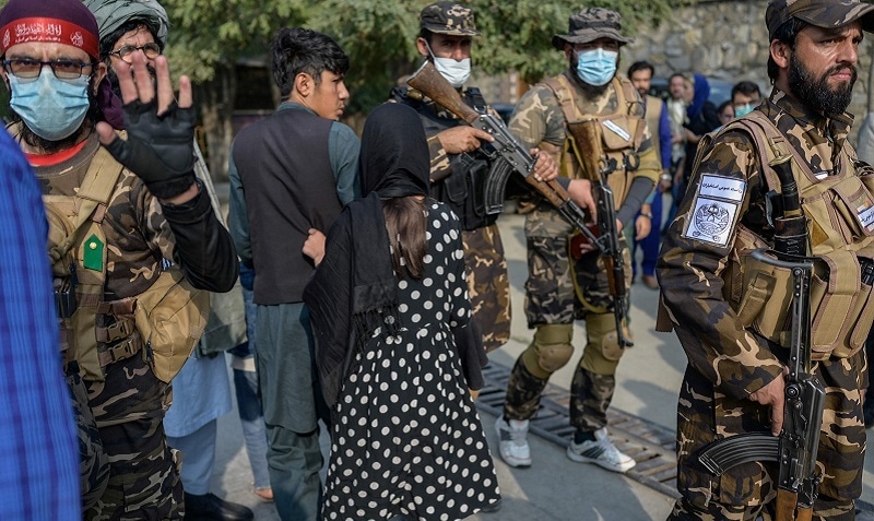A Taliban fighter (L) makes a hand gesture asking the photojournalists to stop covering a demonstration by women protesters in Kabul on Thursday. — AFP