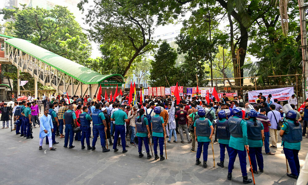 Police personnel stand guard along a street as garment workers and activists protest in Dhaka on November 10, 2023. Photo: AFP
