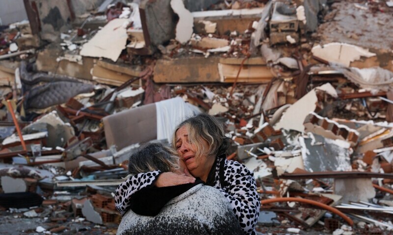 <p>A woman reacts while embracing another person, near rubble following an earthquake in Hatay, Turkiye, February 7, 2023.— AFP</p>