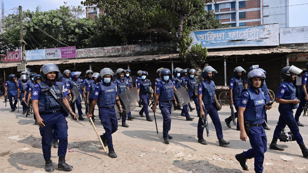 Bangladeshi policemen patrol along a street in Ashulia on November 8, 2023.