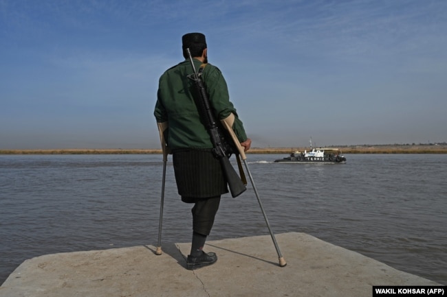 A Taliban fighter watches as a barge arrives from Uzbekistan on the Amu River near the Afghan-Uzbek Border on October 27.