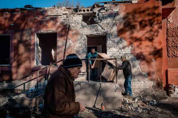 Workers carrying furniture from a hospital maternity unit in Kherson, Ukraine, on Wednesday after Russian shelling damaged the building.