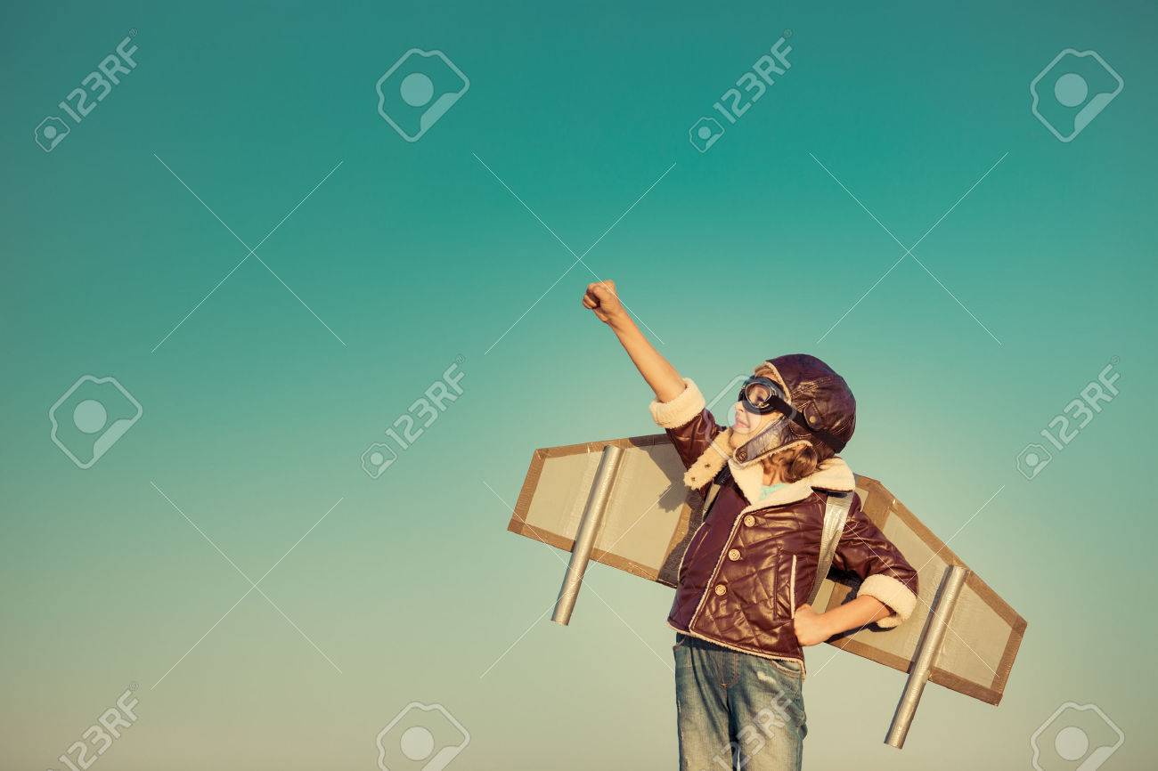 46594516-Kid-pilot-with-toy-jet-pack-against-autumn-sky-background-Happy-child-playing-outdoors-Stock-Photo.jpg