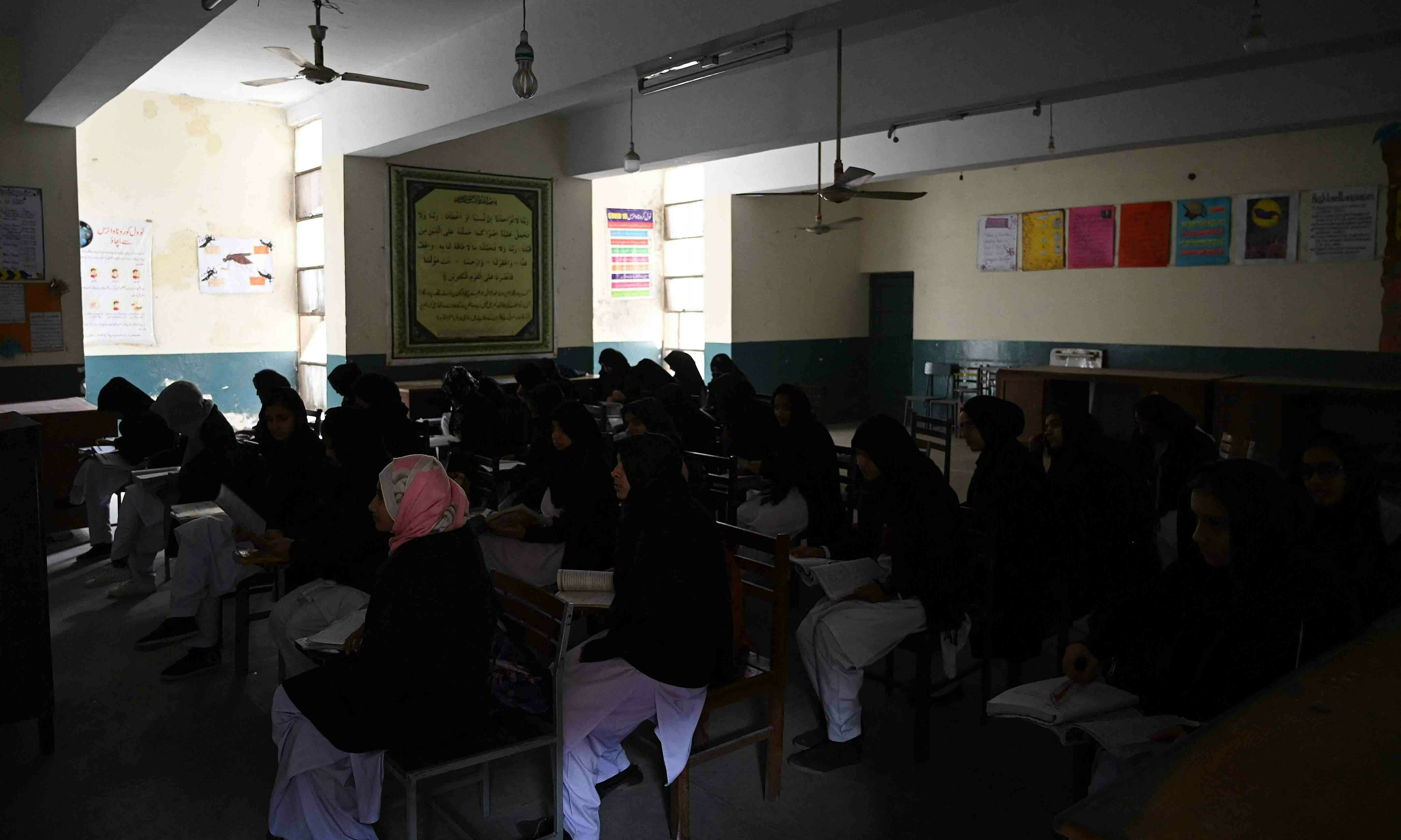 <p>Students attend a class at a government high secondary school during a nationwide power outage in Rawalpindi on January 23. — AFP</p>