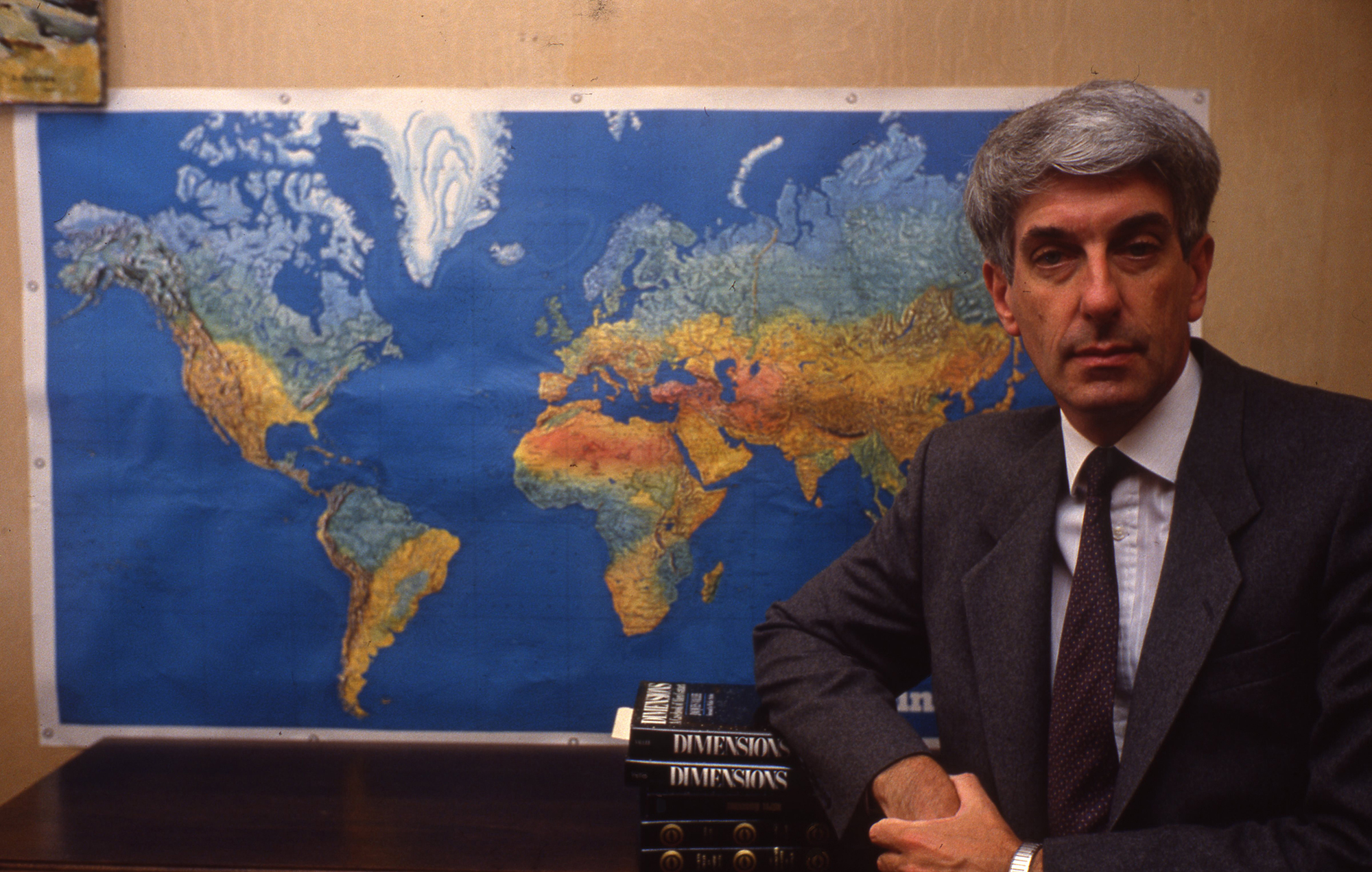 Jaques Vallée stands in front of a map of the world in a 1989 photo. 