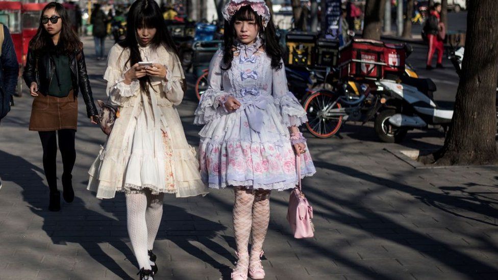 Two girls in cosplay dresses along the street in Beijing
