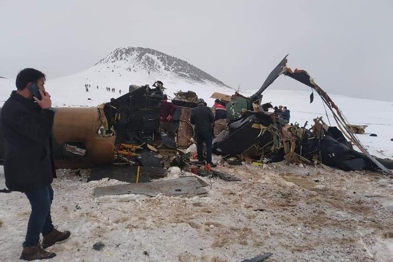 Rescue workers, soldiers and civilians walk around the wreckage of a military helicopter that crashed near the Turkish eastern city of Bitlis [AFP]