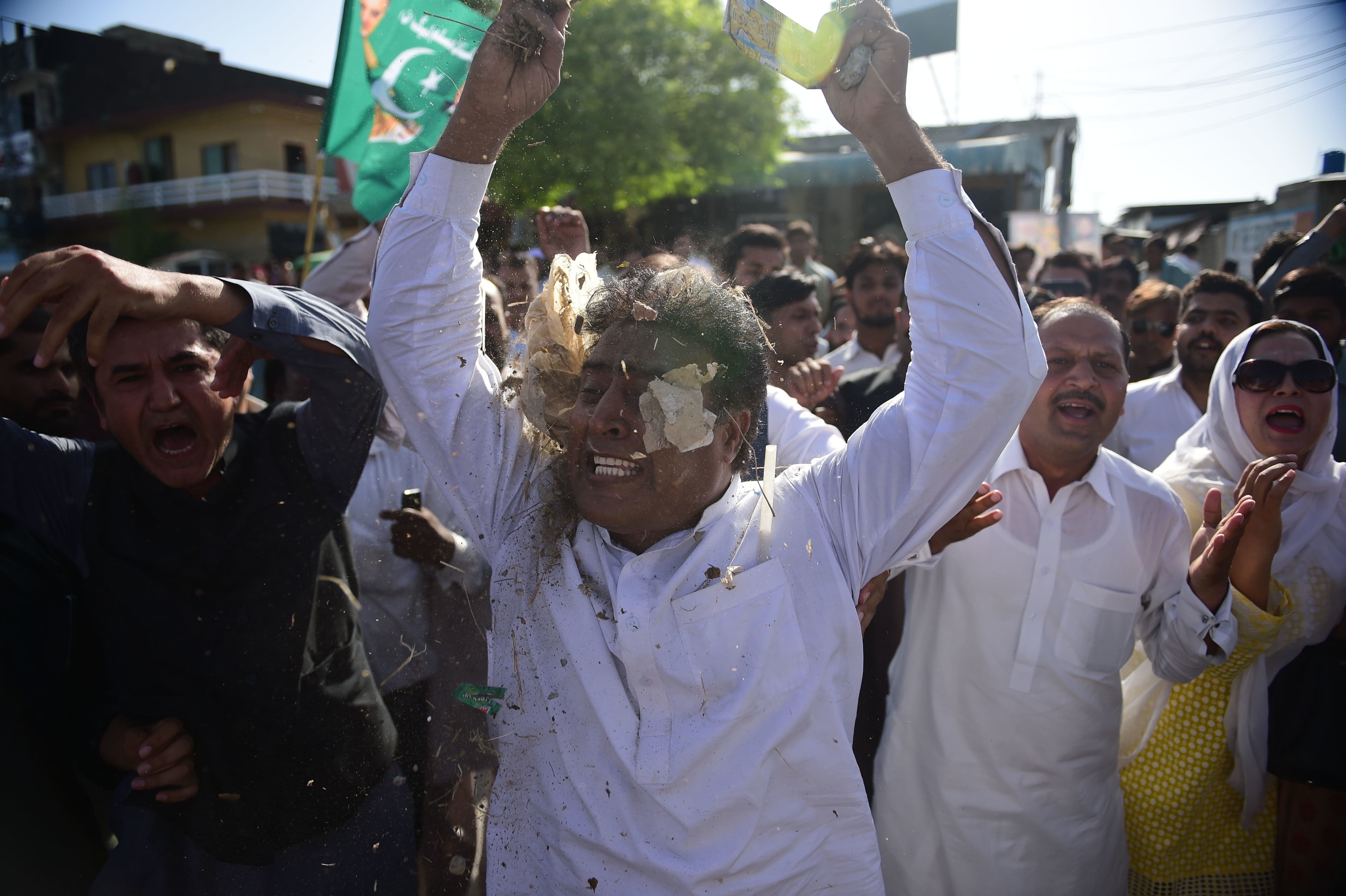 A PML-N activist throws dirt and trash over himself while protesting the accountability court's judgement. — AFP
