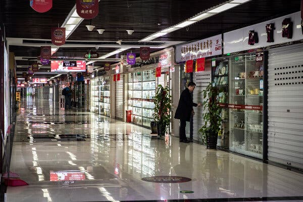 A man locking up a shop in the nearly empty Yiwu Commodities City, in Yiwu, China, in January.