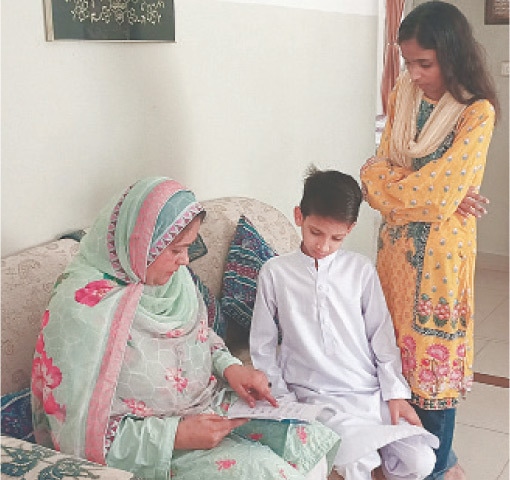 Rubina Khan checks young Kashif’s homework copy with one of his older SOS siblings watching over | Photos by the writer