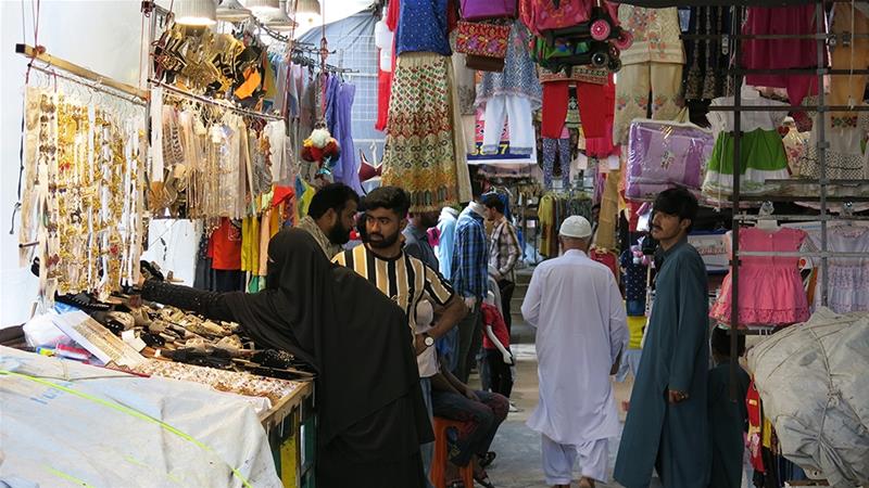 Hardly anyone wears a mask or follows government-mandated social distancing guidelines at Islamabad's busy Karachi Company market [Asad Hashim/Al Jazeera]