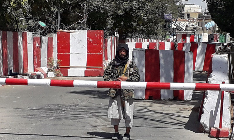 A Taliban fighter stands guard at the entrance of the police headquarters in Ghazni on Thursday as Taliban move closer to Afghan capital after taking Ghazni city. — AFP