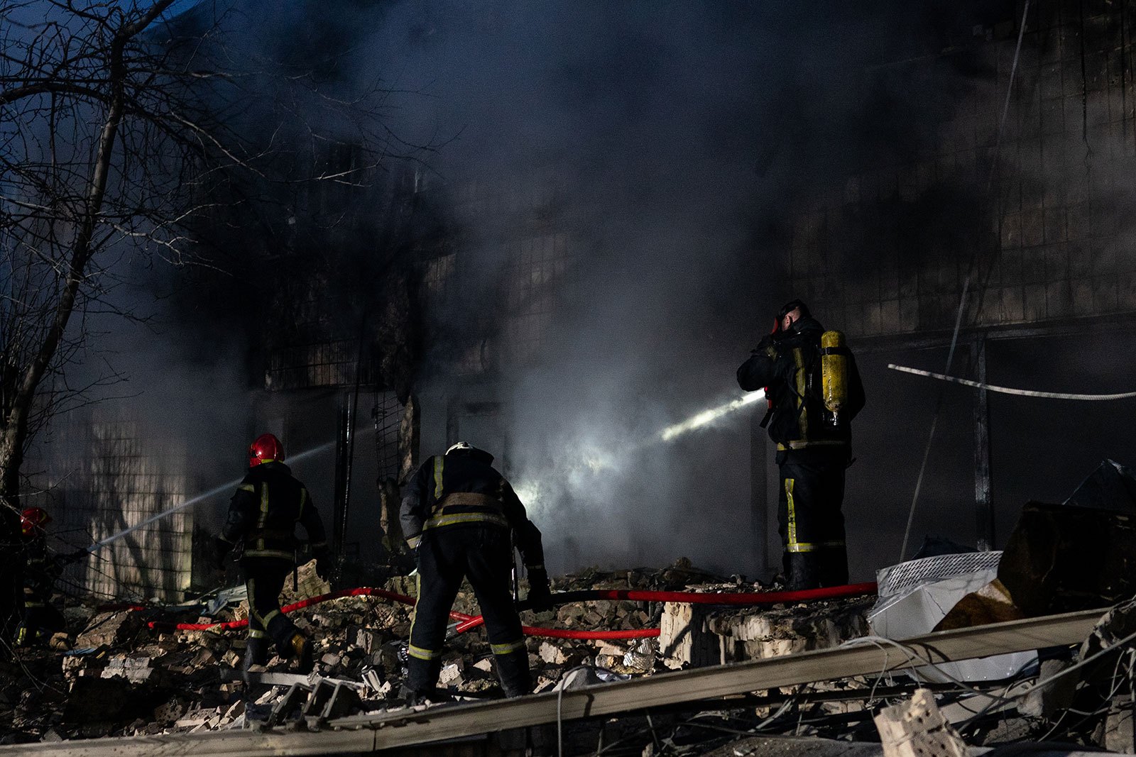 Emergency crews respond to the scene of an airstrike near Kyiv's TV tower on March 1. The nearby Babyn Yar Holocaust memorial site was also hit during the attack.'s TV tower on March 1. The nearby Babyn Yar Holocaust memorial site was also hit during the attack.
