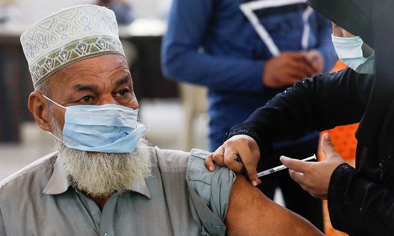 A man receives a dose of a coronavirus booster vaccine, after government permitted a booster shot for healthcare workers, immunocompromised and for the people over 50 years, at a vaccination centre in Karachi, on Thursday. — Reuters