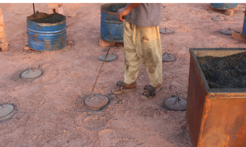 A labourer feeds coal in the brick kiln through feeding hole.