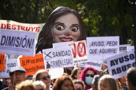 A cartoon of the Madrid regional government's leader Isabel Ayuso over the heads of thousands of protestors in Madrid, Spain, on November 13, 2022. [Rodrigo Minguez/NurPhoto/Getty Images]