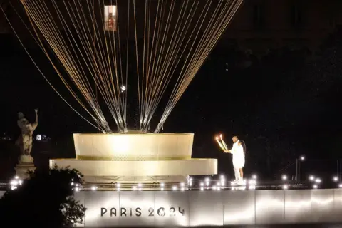  Miguel Tona/EPA The torchbearers Marie-Jose Perec and Teddy Riner (R) walk to light up the Paris 2024 Hot-air Balloon Olympic Cauldron during the Opening Ceremony of the Paris 2024 Olympic Games