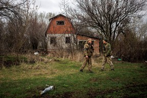 Ukrainian soldiers stand outside the abandoned Russian outpost in Husarivka, in Kharkiv region, on April 14, 2022.