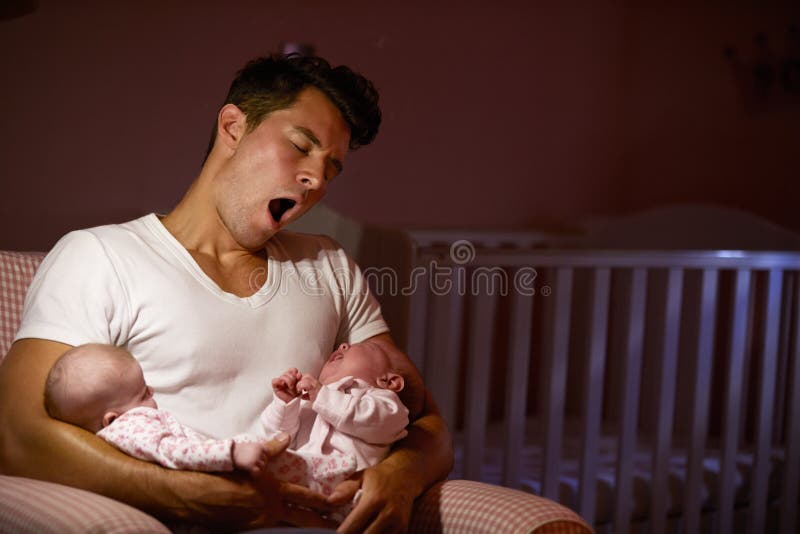 tired-father-home-cuddling-twin-baby-daughters-nursery-52852946.jpg