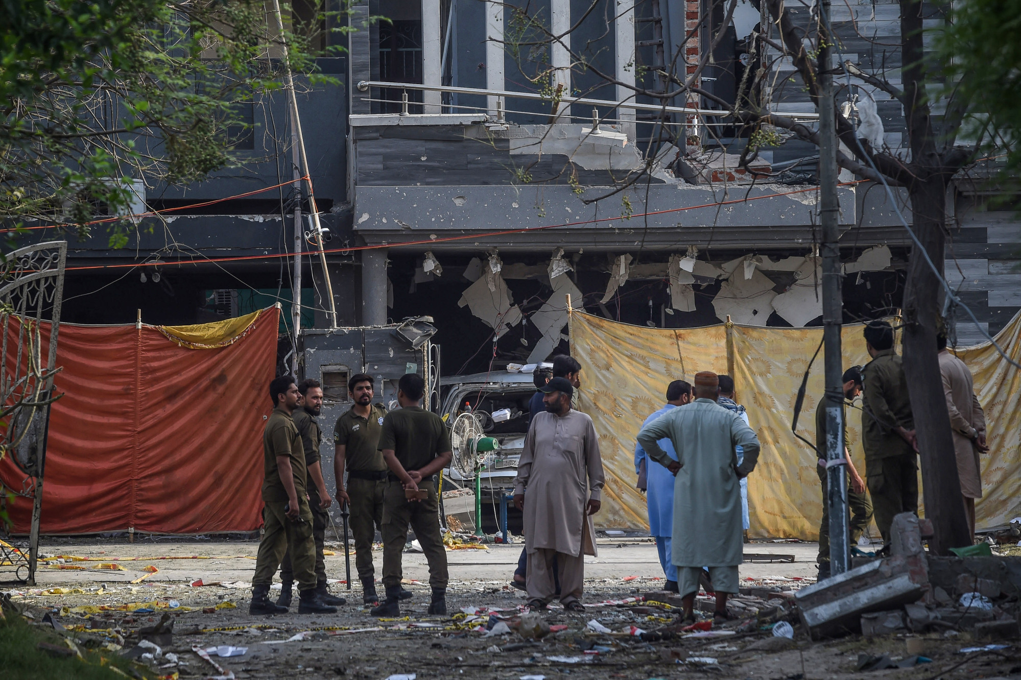 Police and locals near the site of the June 23 car bomb that killed three people in Lahore. Photo: AFP