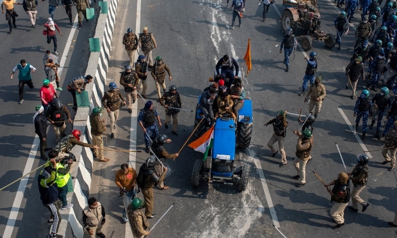 Indian policemen beat farmers driving a tractor after protesting farmers and policemen clash during India's Republic Day celebrations in New Delhi, Jan 26. — AP