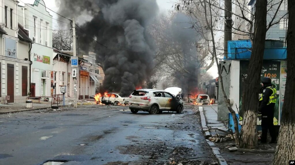 FILE - Cars burn and smoke raises after a deadly Russian rocket attack hit the city center in Kherson, Ukraine, Dec. 24, 2022. 
