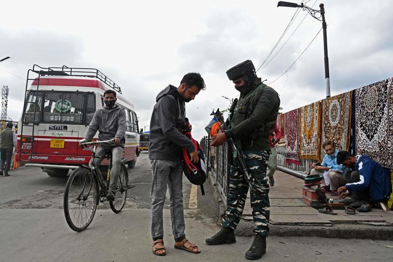 A security officer checks the bag of a pedestrian along a street in Srinagar on Monday, as suspected militants shot dead five soldiers in Indian-administered Kashmir. (AFP photo)