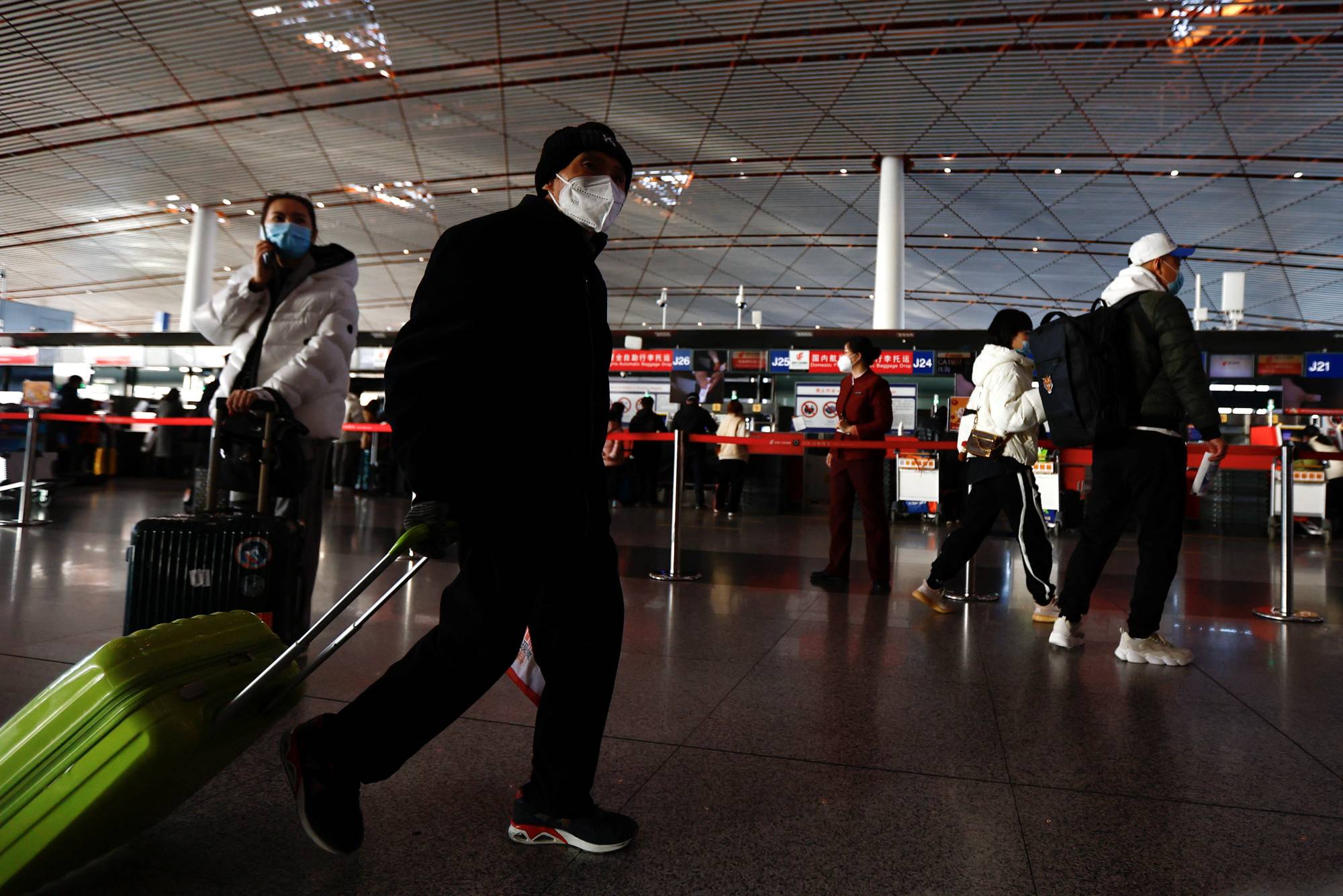 Travelers move through the terminal at Beijing Capital International Airport on Jan. 18. | REUTERS 