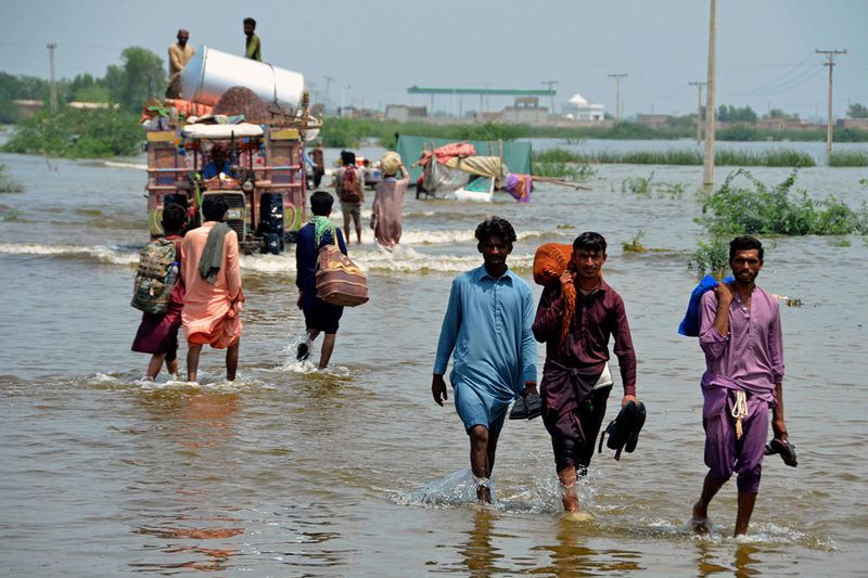 People wade through a flooded area of Sohbatpur, a district of Pakistan's southwestern Baluchistan province.